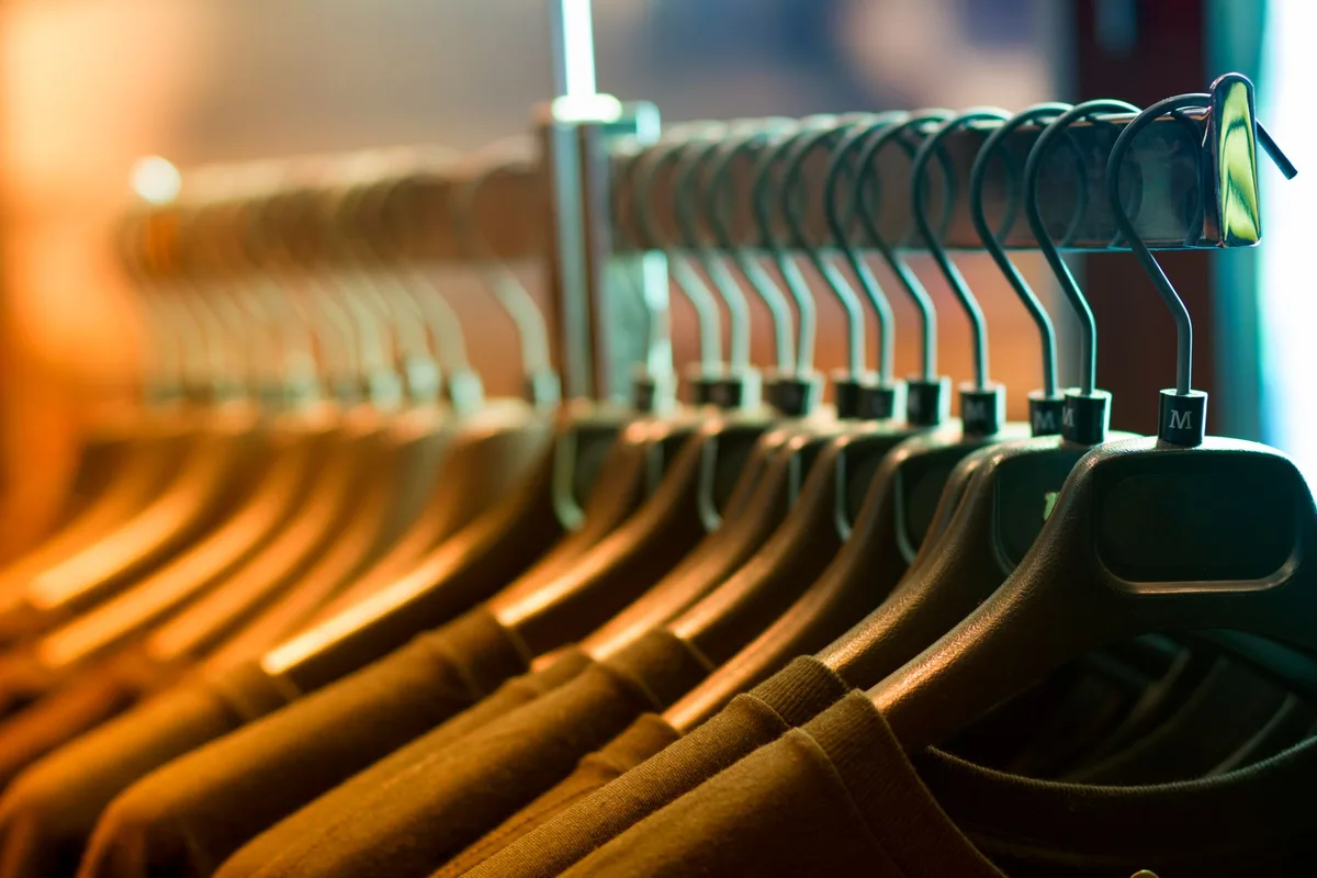 Well-organized reselling inventory with clothing racks and labeling system