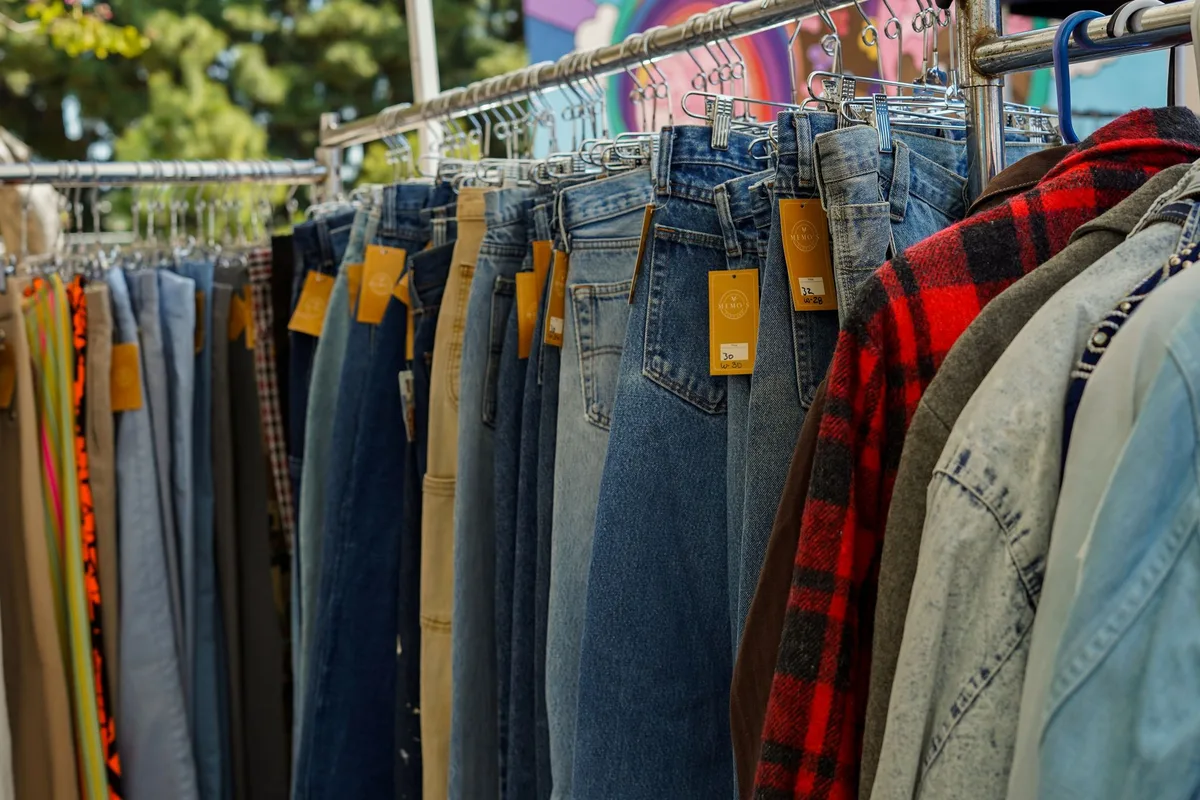 Stack of vintage Levi's jeans and designer clothing ready for online resale