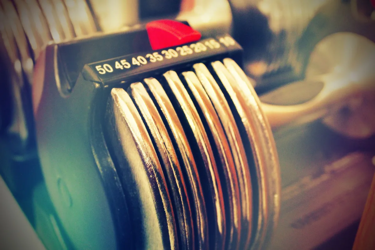 Set of adjustable dumbbells on home gym floor