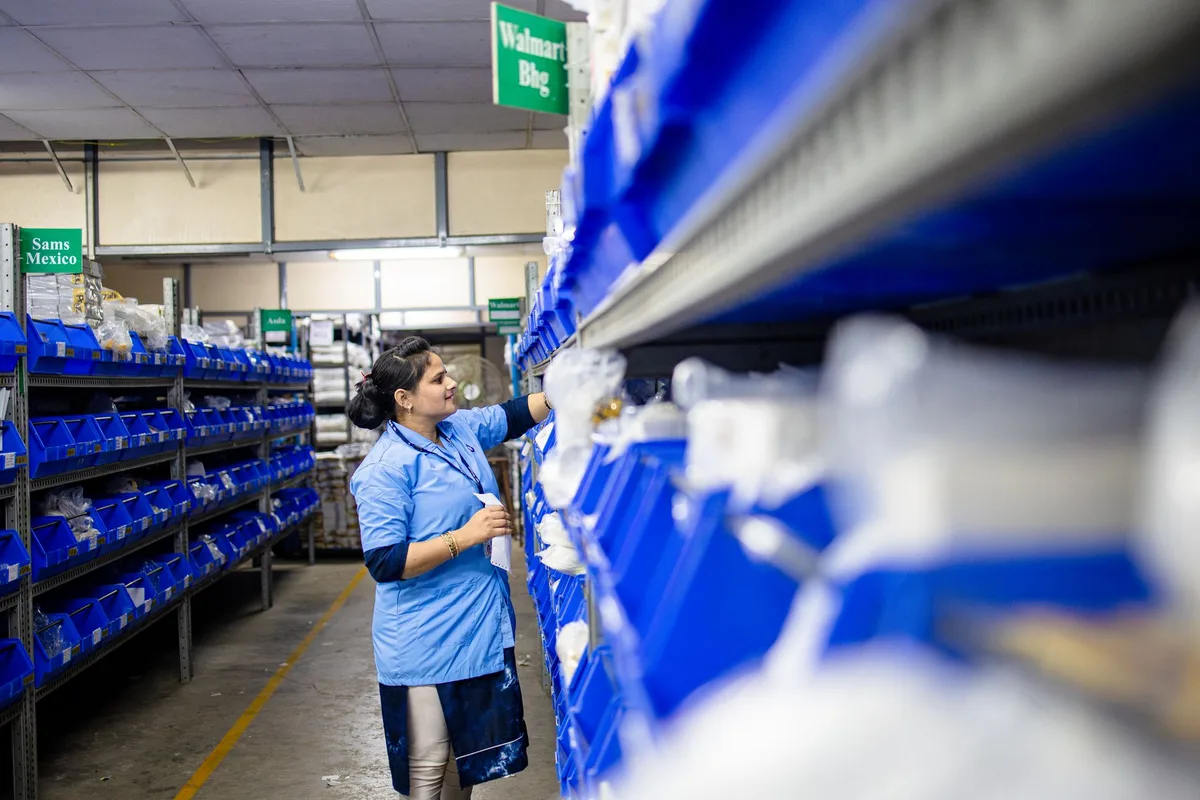 Organized warehouse-style shelving system with labeled bins containing resale inventory