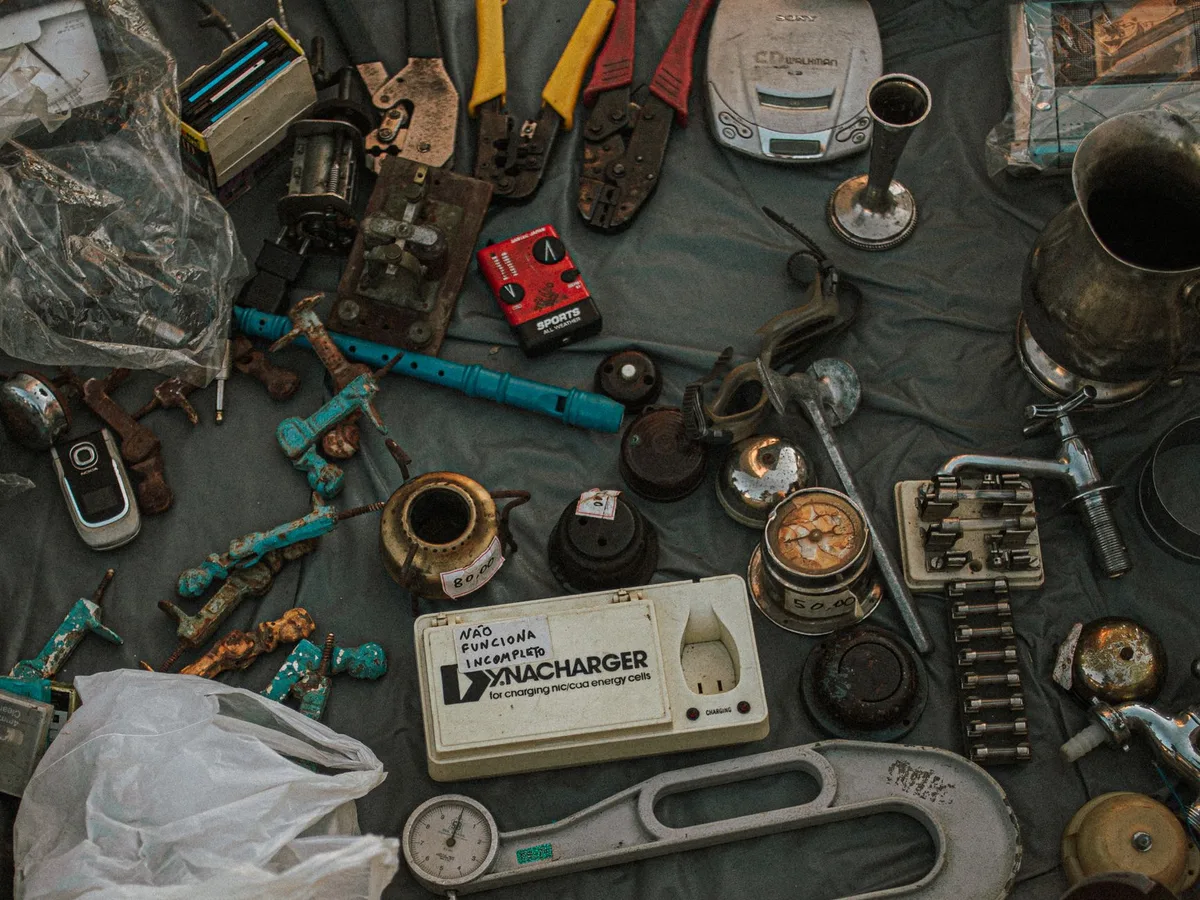 Assorted secondhand items laid out for resale including clothing, electronics, and toys