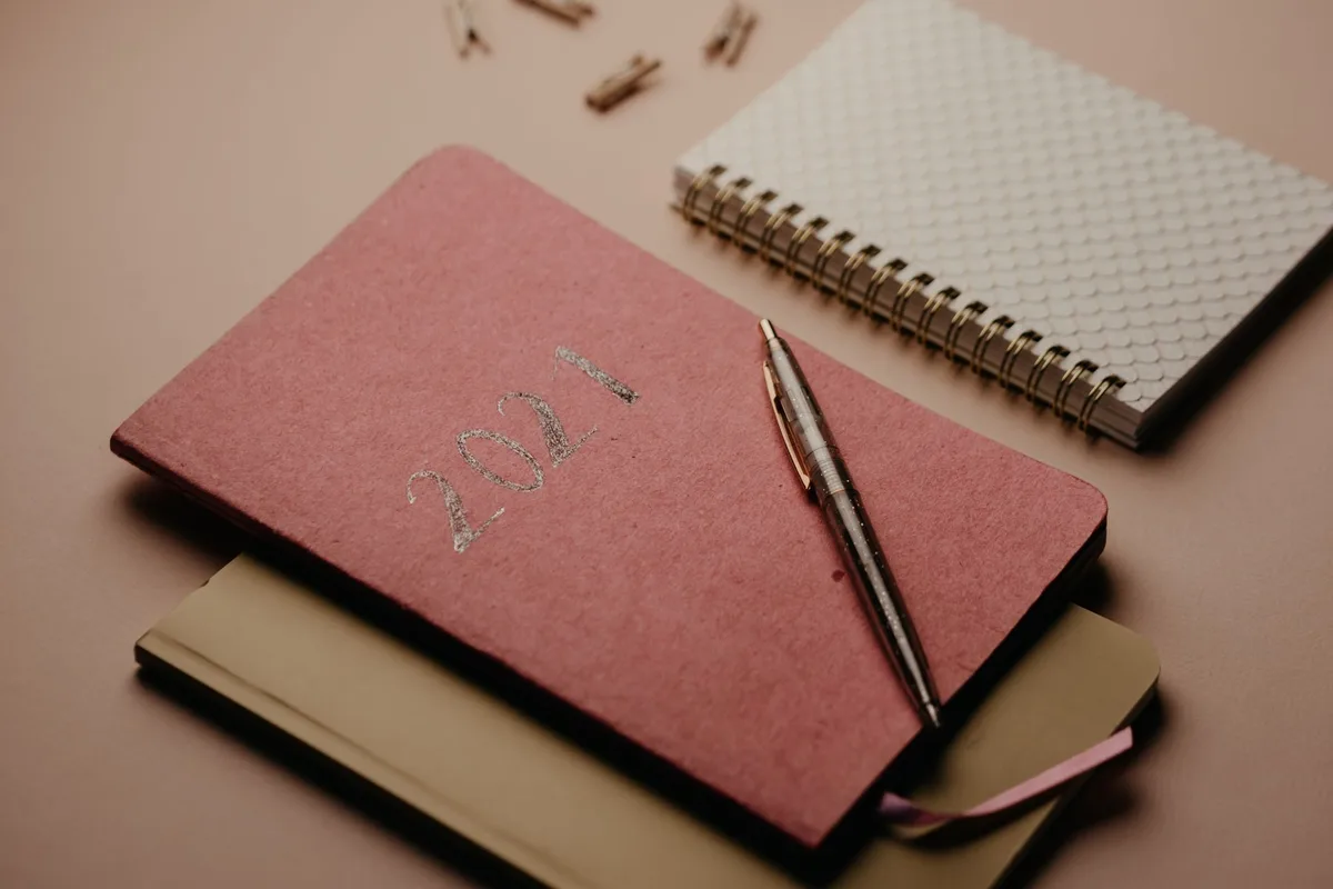 Open planner with written goals and coffee cup on desk