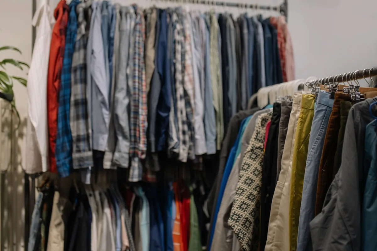Rows of secondhand clothing on racks at a thrift store