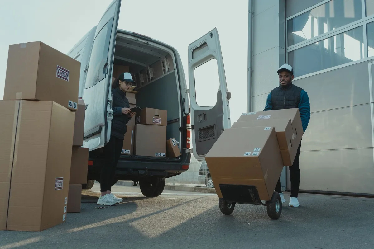 Entrepreneur packing boxes and shipping orders from a home workspace.