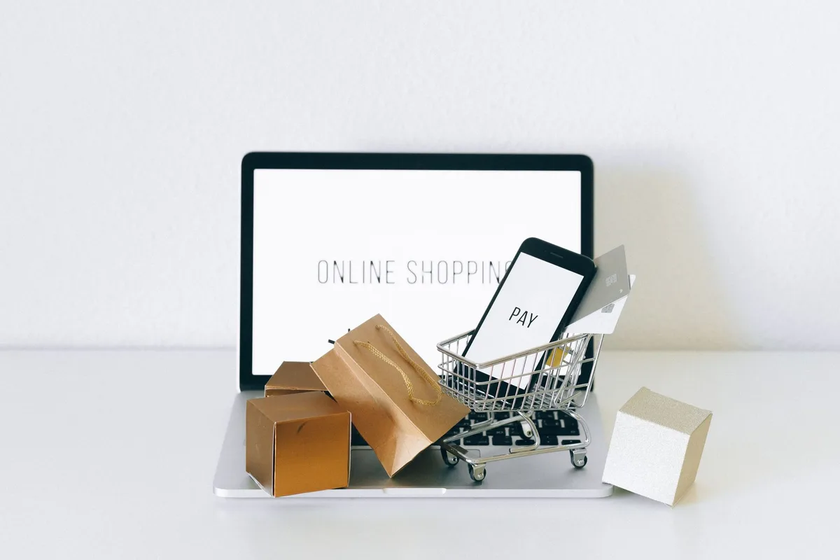 A reseller photographing clothing for online listings with a smartphone and portable light setup